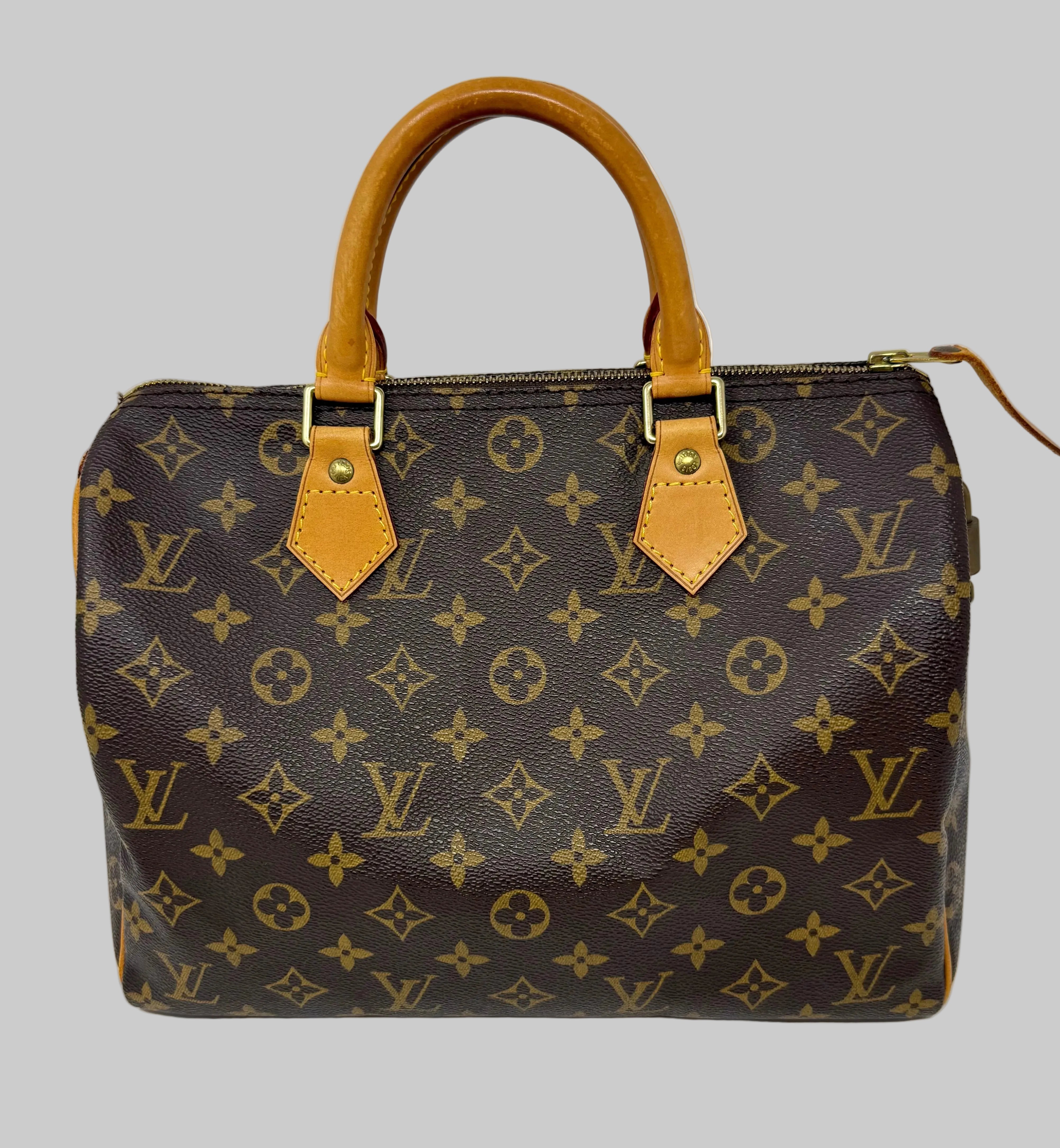 Louis Vuitton monogram canvas handbag with tan leather top handles and gold-tone hardware, photographed against a plain light gray background.